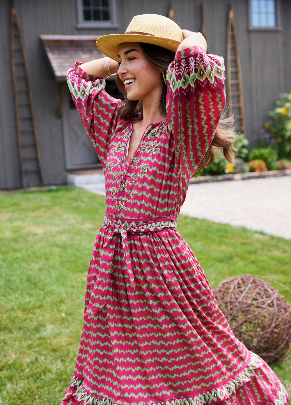 Elsa Dress in Ikat Stripe Cranberry, on a lawn by a barn