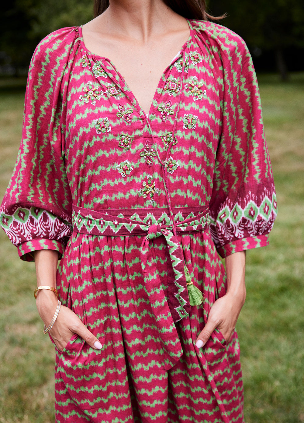 Elsa Dress in Ikat Stripe Cranberry, closer front view on a lawn