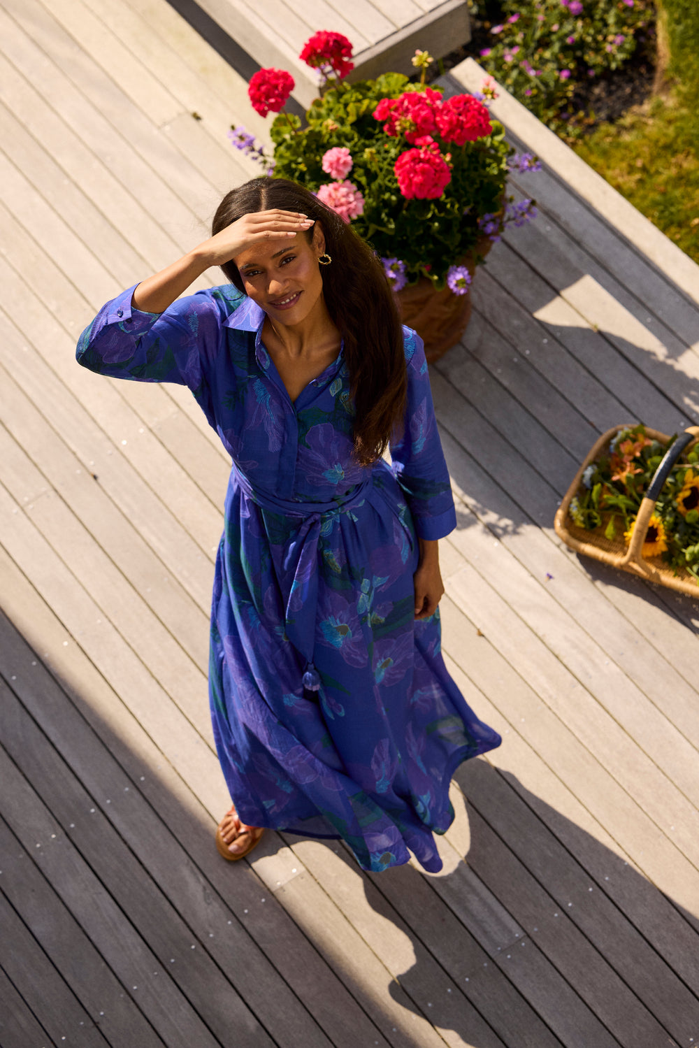 Kit Shirtdress in Helin Royal, front view on a deck beside potted flowers