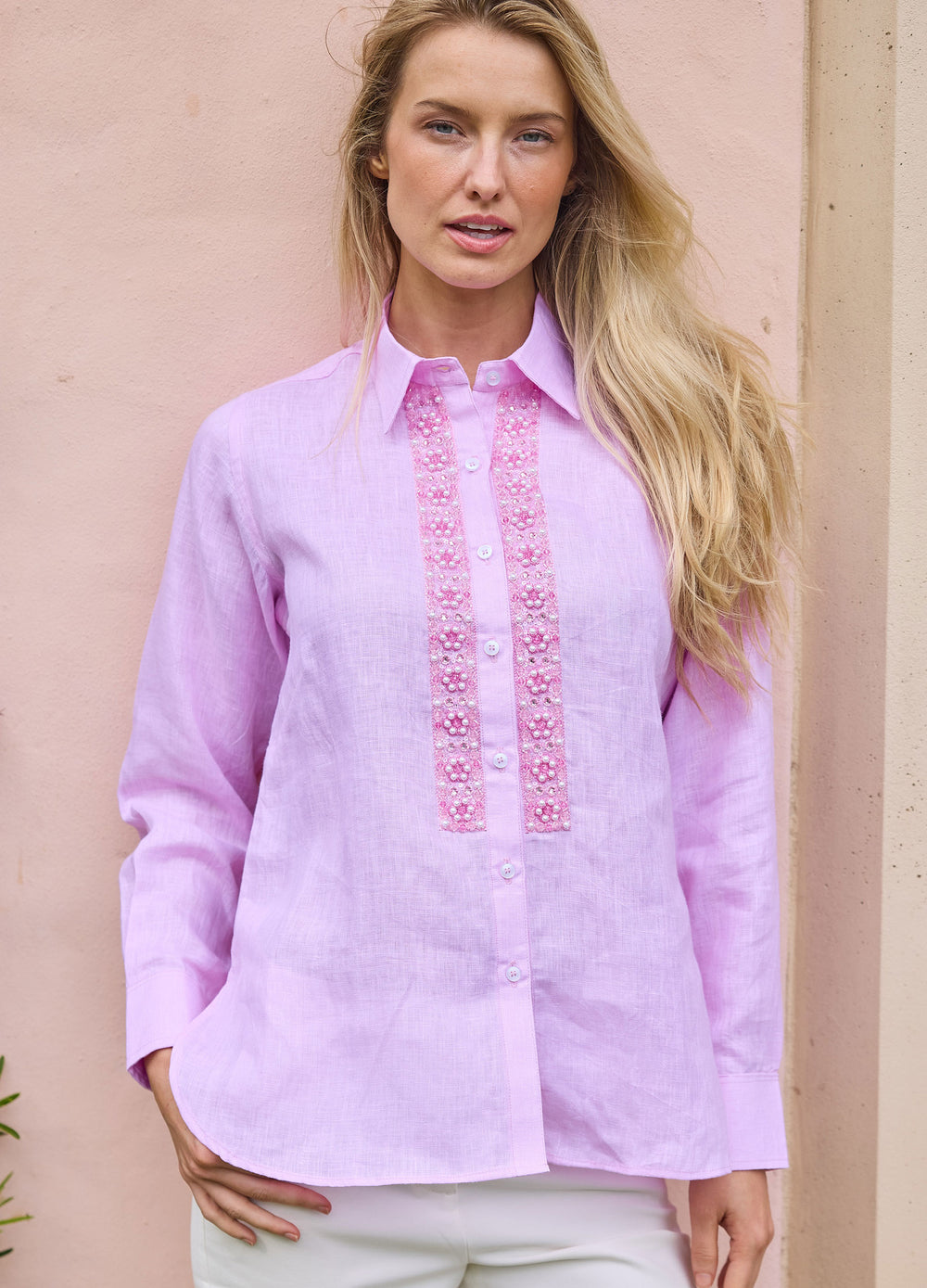 Pearl Flower Shirt in Pink, front view against a wall, hand on hip