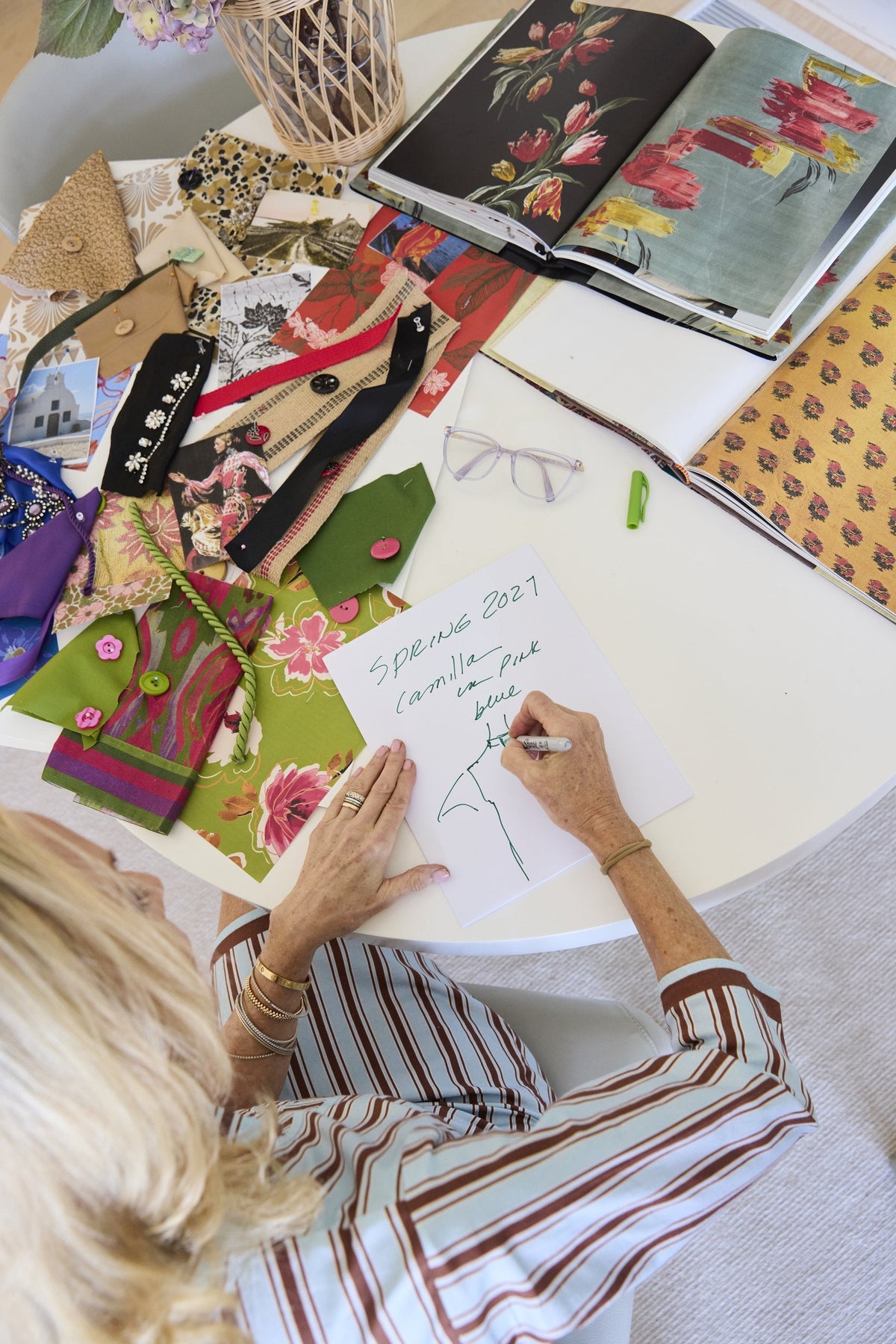 Jeanne Daniel at her desk, surrounded by fabric swatches and trims
